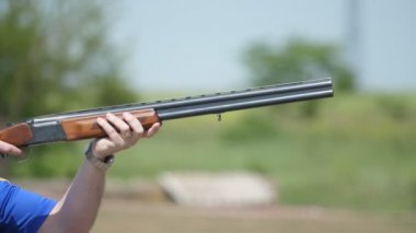 Mavi gökyüzü ve slo-mo bir dizi bir çift namlulu silah çekim cesur bir adam hedef ve slo-mo yaz aylarında geniş bir yelpazede kil plakalar onun over-and-under tüfek çekim çarpıcı görünümü