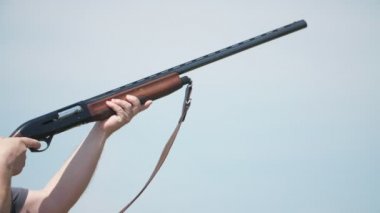 Cesur adam yetiştirme ve slo-mo yaz aylarında mavi gökyüzü ile aralığında uçan skeet güvercinler ateş profesyonel bir adam slo-mo Riveting görünümünde yaz aylarında aralığında kil güvercinler ateş