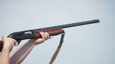 Tek namlulu tüfek çekim ve kartuş durumda slo-mo heyecan verici bir yükseltilmiş on-namlu av tüfeği görme kilidi ihlal dışarı yükselen nişan ve kil güvercin ateş. Slo-mo'da uçan boş bir kartuş kılıfı