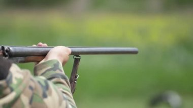Yavaş çekimde yaz aylarında bir dizi bir yan yana tüfekten çekim Adam slo-mo güneşli bir günde yeşil bir alanda bir yan yana av tüfeği çekim askeri üniformalı bir adamın etkileyici görünümü