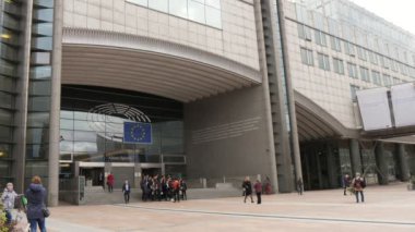 Brüksel, Belçika-1 Nisan 2019: bahar aylarında güneşli bir günde Brüksel 'de AB bayrağı ile Avrupa Parlamentosu girişinde yoğun devlet yetkililerinin Iyimser görünümü.