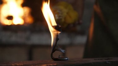 Güzel gül bir demirci atölyesinde arka planda yanan fırın ile büyük bir örs koymak erimiş bir gül demir bir demirci atölyesinde bir demirci atölyesispellful görünümünde alev kaplı bir çelik örs yerleştirilir. 