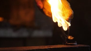 Ferforje gül bir atölyede alev kaplı bir çelik örs üzerine konur Demirci atölyesinde arka planda parlak fırın ile büyük bir örs koymak yanan bir gül demir çarpıcı görünümü. 