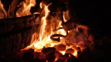 Eski bir Ukrayna demirci atölyesinde yüksek çatallı köpüklü fırın alevi demirci demirci demirde komik bir şekilde oynayan ateşin canlı çatalları ile ferforje metal işçiliği için yanan bir ocağın sihirli görünümü.