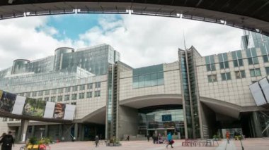 Brüksel, Belçika - 1 Nisan 2019: İlkbaharda Brüksel'de büyük bir kemeri olan ve zaman atlamalı bulutlu gökyüzüne sahip Avrupa Parlamentosu bina kompleksinin heyecan verici manzarası