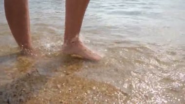 Yaz aylarında güneşli bir günde deniz kıyısında gezinen kadın ayakları yavaş çekimde alanya'da güneşli bir günde alanya'da dalgalarla deniz kıyısında yürüyen sağlıklı kadın ayaklarının heyecan verici yakın çekimini