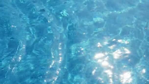夏のパドリング池で陽気に振る輝く水色の水は スローモーションで夏のスイミングプールで輝くクモの巣を形成する金色の太陽の光で突き刺さったターコイズブルーの水の感動的な眺め — ストック動画