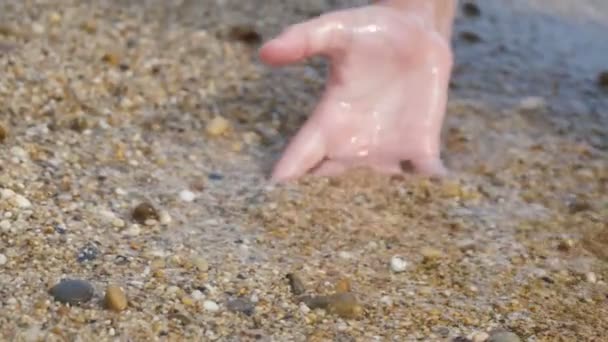 手入れの行き届いた手が掘り スローモーションで素敵な夕日にアランヤの海岸で砂と貝殻を保持する女性の手のゴージャスなクローズアップで日没時に海岸に砂を保持 — ストック動画