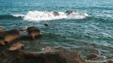 Alanya'da yaz aylarında kayalar ve köpüklü dalgalar la Karadeniz kıyıları, yaz aylarında slo-mo'da köpüren dalgaların altında büyük kayalar ve küçük çakıl taşları ile Karadeniz sahilinin rahatlatıcı görünümü