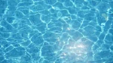 Slo-mo'da güneşli bir günde yüzme havuzunda mutlu bir şekilde eğlenen masmavi dalgalar, Türkiye'de güneşli bir günde yüzme havuzunda parlayan ışık ışınlarının bir örümcek ağıyla gök suyunun muhteşem manzarası 