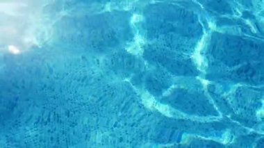 Pırıl pırıl su yavaş hareket yavaş hareket içinde yaz güneşli bir günde güneşli bir günde turkuaz suları ve güneşli ışınları parlayan ağ ile bir wading havuzun slo-mo Muhteşem görünümü nde yaz güneşli bir günde güneşli bir günde bir yüzme havuzunda hareket.