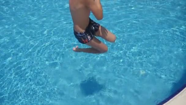 年轻人在阳光明媚的日子里在游泳池里先跳脚 在慢动作的阳光下 一个穿着短裤运动的男子在夏天的阳光明媚的日子里 在游泳池里跳脚 — 图库视频影像