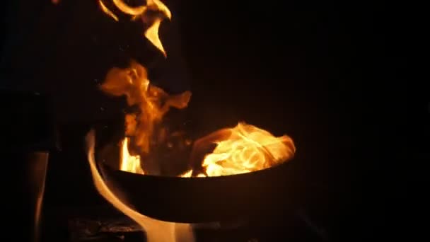 Fourchettes de feu jouant sur une poêle gardée par le chef à la cuisine extérieure à Pékin Vue impressionnante d'une flamme magique dansant sur une grande poêle gardée par un chef dans un restaurant en plein air en Turquie la nuit au ralenti 