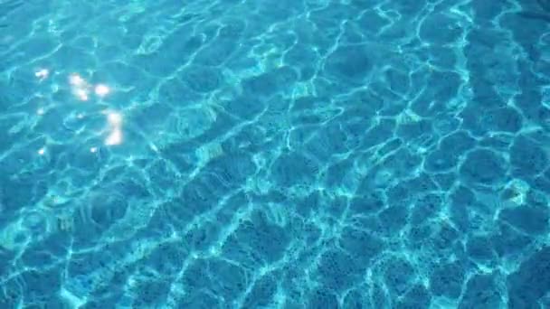 夏のアラーニャの輝くスイミングプールの明るいアズールの水は スローモーションで夏のアラーニャの陽気なスイミングプールで金色の太陽の光の完全な輝くアズールの水の華やかな背景ビューで — ストック動画