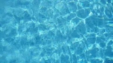 Canlı turkuaz su yavaş hareket bir çocuk havuzunda ışık ile parıldayan canlı turkuaz sular parlayan güneşli dolu parlak arka plan görünümü ışık ile oynuyor ve yavaş hareket yüzme gölet örümcek ağları oluşturan. 