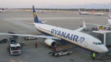 Antalya, Türkiye-14 Haziran 2019: yaz aylarında güneşli bir gün Alanya 'da büyük bir beyaz yolcu uçağı uzağa gidiyor bir kamyonla sabit birçok Bagaj Barrows heyecan verici görünümü