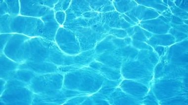 Aydınlık bir yüzme havuzunda yavaş hareket parlayan güneş ışınları bir ağ ile parlayan turkuaz suların muhteşem arka plan görünümü, güneşli güneşlerle dolu turkuaz sular