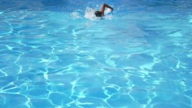 Sportif çocuk yavaş hareket içinde bir turkuaz Wading gölet içinde Freestyle yüzme atletik bir genç yüzme Freestyle profesyonel yavaş hareket köpüklü turkuaz suları ile bir kürek gölet çarpıcı görünümü