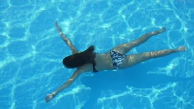 Slo-Mo bir Wading havuzunda su altında çekici kız yüzme emzirme bikini içinde uzun saçlı bir ince esmer kadının muhteşem görünümü su altında bir deniz kızı gibi gözlüklerle sualtı emzirme