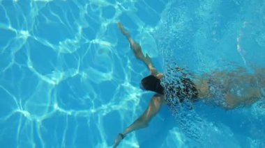 Bikini içinde ince bir kızın komik görünümü Slo-Mo ' y a su altı emzirme içinde Bikini Yüzme sualtı bikini içinde ince bir esmer kız görünümü, Güneş ışınları ile bikinili su içinde tuhaf Slo-Mo formları değiştirme 