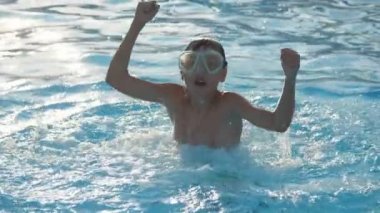 Bir maske neşeli çocuk su batımında deniz dalgalarında yüksek atlama olduğunu küçük bir çocuk sıçrama ve yavaş hareket yaz aylarında günbatımı Karadeniz dalgalarında yükseltilmiş yumruklar ile yüksek yukarı atlama harika görünümü