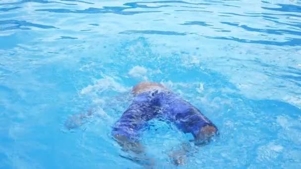 Chico Alegre Haciendo Sommersault Espalda Una Piscina Chispeante Cámara Lenta — Vídeo de stock