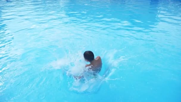 Glad Pojke Hoppar Fötterna Först Och Snurrar Runt Swimmingpool Slo — Stockvideo