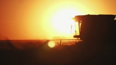 Etkileyici bir dönen eşeri ile birlikte muhteşem gün batımı, slo-mo ile harmanlanmıştır bir görmek-Through kabin ile yorucu bir kombine hasat muhteşem görünümü gidiş ve yavaş hareket göz kamaştırıcı kirişler ile altın günbatımı büyük alanda buğday toplama