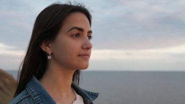Tatlı kız onun bal ayı için Karadeniz 'de yaz mevsiminde gün batımı içinde bekleyen uzun gevşek saç ve derin gözleri çırpınan ile zarif bir genç kadının Inspiring görünümü yaz aylarında bir gün batımı içinde Karadeniz 'de onu Hulk adam bekliyor Slo-Mo