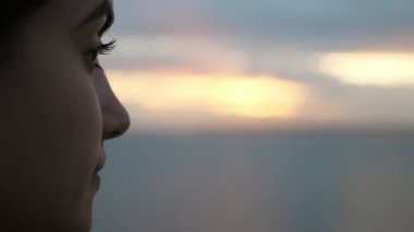 Slo-Mo gün batımında Karadeniz sularında zevk uzun gevşek saç ile ihale kız görünümlü ve Slo-Mo yaz aylarında karanlık günbatımı Karadeniz dalgaların görünümü zevk tür gözleri ile rüya genç esmer kız Ilham profili  