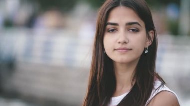 Neşeli genç güzellik yavaş hareket te yaz Aylarında Dnipro rıhtımda mutlu bir şekilde gülümseyen uzun gevşek saçları ve pırıl pırıl gözleri ile cesur esmer kız Amazing bokeh görünümü mutlu bir şekilde gülümseyen ve slo-mo yaz aylarında Dnipro seti üzerinde hayatının tadını