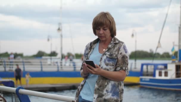 Elegante Mujer Rubia Mensajes Texto Teléfono Sentado Sobre Rieles Muelle — Vídeo de stock