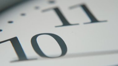 Beyaz saat yüz hareketli bir ikinci el on ve on bir sayı geçen etkileyici closeup bir vintage beyaz saat yüz hızlı bir şekilde on ve on bir sayı ile geçen hareketli bir siyah ikinci el aslant yerleştirilir.