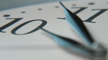 Retro saat yüz üç keskin siyah elleri ile geleneksel beyaz saat yüz on Wonderful closeup beş dakika gösteren üç ok şeklinde siyah elleri on ve on bir sayı işaret askew yerleştirilir. Bu 10 dakikaya beş dakika..