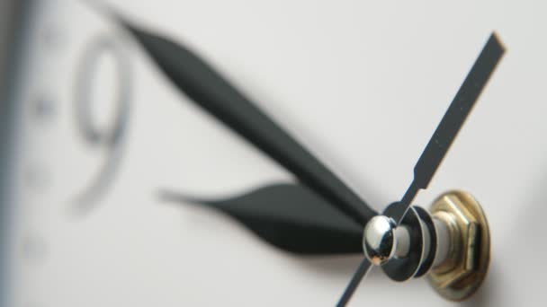 Visage d'horloge blanche avec trois aiguilles noires étroites montrant neuf minutes à neuf Gros plan frappant d'un visage d'horloge blanche à l'ancienne placé en biais avec trois aiguilles noires en forme de flèche se déplaçant, en cliquant et pointant à neuf minutes à neuf .