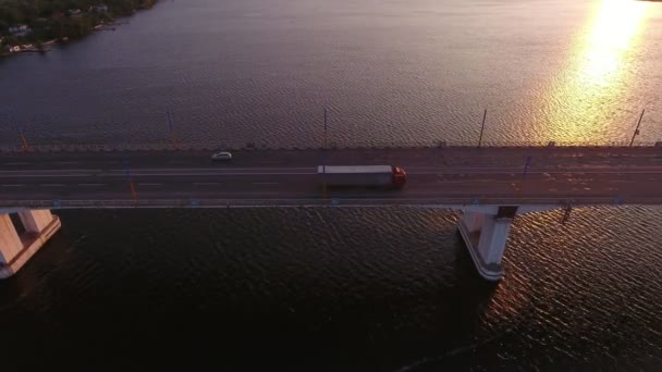 ドニプロに架かるまっすぐな川の橋の空中写真は 夏のウクライナの素敵な夕日の美しい太陽の道で 長い橋の長い鳥の目のビューを見事に見て 美しい太陽のパスで紫色の水を波打ちます — ストック動画