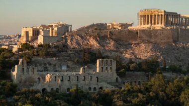 Antik Atina Akropolis gün batımında yüksek sütunlar ile çekilen bir timelapse shot Gorgeous dev sütunlar ve altın görünümlü duvarlar ile Atina Akropolis zaman atlamalı uzak kırpın yaz aylarında gece gündüz pırıl pırıl günbatımı bir tepelik alanda