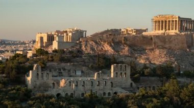 Antik Atina Akropolis gün batımında büyük sütunlar ile çekilen bir timelapse shot Muhteşem zoom Atina Akropolis timelapse yüce sütunlar ve altın görünümlü duvarlar yaz aylarında gece gündüz ışıltılı gün batımı bir tepelik alanda