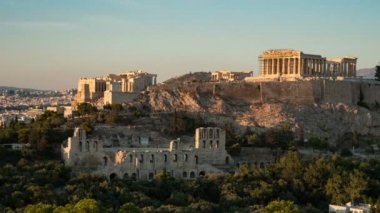 Antik Atina Akropolis yaz aylarında ciddi sütunlar ile çekilen bir timelapse çekim Klasik sütunlar ve altın görünümlü duvarlar ile Atina Akropolis yaz aylarında gün batımı gün batımı parlayan bir dağlık alanda