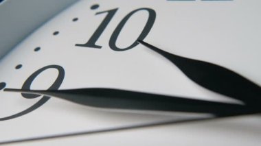 Üç keskin siyah elleri ile beyaz saat kadranı on beş dakika on on heyecan verici closeup bir vintage görünümlü beyaz saat kadran üç ok siyah elleri on ve dokuz numaraları işaret aslant yerleştirilir. 10 dakikaya 15 dakika..