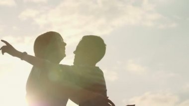 Küçük çocuk annesine gidiyor, atlama ve slo-mo kısa saç kesimi ile küçük bir çocuğun güzel gün batımında ona sarılma, atlama ve slo-mo yaz aylarında pırıl pırıl günbatımında onu mutlu bir şekilde sarılma