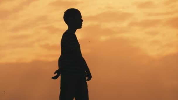 Niño Deportivo Agitando Sus Manos Una Manera Relajada Atardecer Naranja — Vídeo de stock