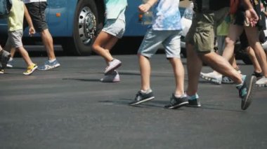 Atina, Yunanistan - 15 Ağustos 2019: Slo-mo'da yazın güneşli bir günde Atina'da bir caddede dolaşan şort ve pantolonlu turistlerin ayaklarının iyimser görünümü. Gezmeye gidiyorlar ve neşeli görünüyorlar..