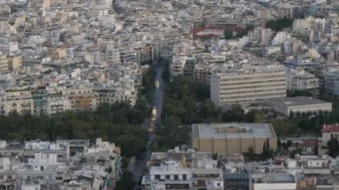 Güneşli bir günde, Atina 'nın yüksek bir tepesinden çarpıcı bir manzara. Güneşli bir yaz gününde, çeşitli idari ve tarihi binalar, sık ahşap ve anıtlarla günümüz Atina' sının muhteşem panoramik manzarası..