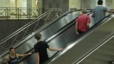 Atina, Yunanistan - 15 Ağustos 2019: Aktif yolcu ve turistlerin yazın Atina metro istasyonunda hareket halindeki bir merdivende hareket etmeleri heyecan verici bir manzara. Son derece teknolojik ve Avrupa 'ya benziyor..