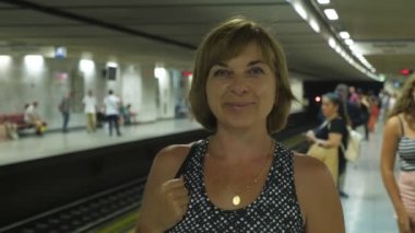 Yazın Atina metro istasyonunda ayakta duran ve gülümseyen neşeli sarışın kadın yazın Atina metro istasyonunda ayakta duran ve gülümseyen kısa saçlı mutlu sarışın bir kadın. Neşeli ve komik görünüyor..