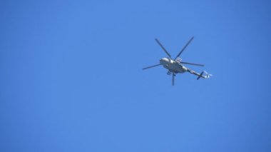 Ordu haki helikopter hovering ve yavaş hareket büyük askeri yeşil ve beyaz helikopter büyük askeri yeşil ve beyaz helikopter görünümü aşağı heyecan verici sonbaharda mavi gökyüzünde uçan ve yavaş hareket mavi havada uçan sonbaharda mavi havada uçan ve. Ufuksuz alanı izler..