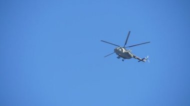 Büyük Ordu haki helikopter yavaş hareket te sonbaharda mavi havada uçan büyük askeri yeşil ve beyaz rotorcraft büyük askeri yeşil ve beyaz rotorcraft görünümü aşağı aşağı etkileyici ve yavaş hareket sonbaharda mavi gökyüzünde uçan. Bölgeyi izler..