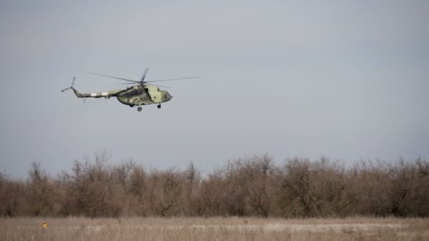 オデッサ ウクライナ 2018 大きなコックピットと回転ブレードを持つ白と緑の軍用ヘリコプターの印象的な眺めは スローモーションで秋に曇った空とフィールドの上をゆっくりと飛んで — ストック動画