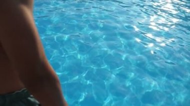 Neşeli adam yavaş hareket bir yüzme havuzunda pırıl pırıl açık mavi sularda bir serçe gibi dalış sportif bir rakam dalış ile genç bir brunet adam slo-mo Muhteşem görünümünde parlayan suları ile bir kürek havuzunda ilk baş atlama.
